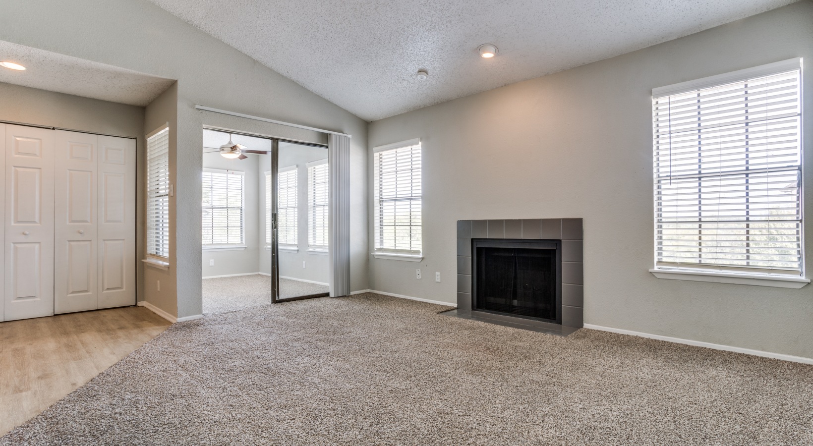 empty living room with fireplace and sliding glass door at The Hudson