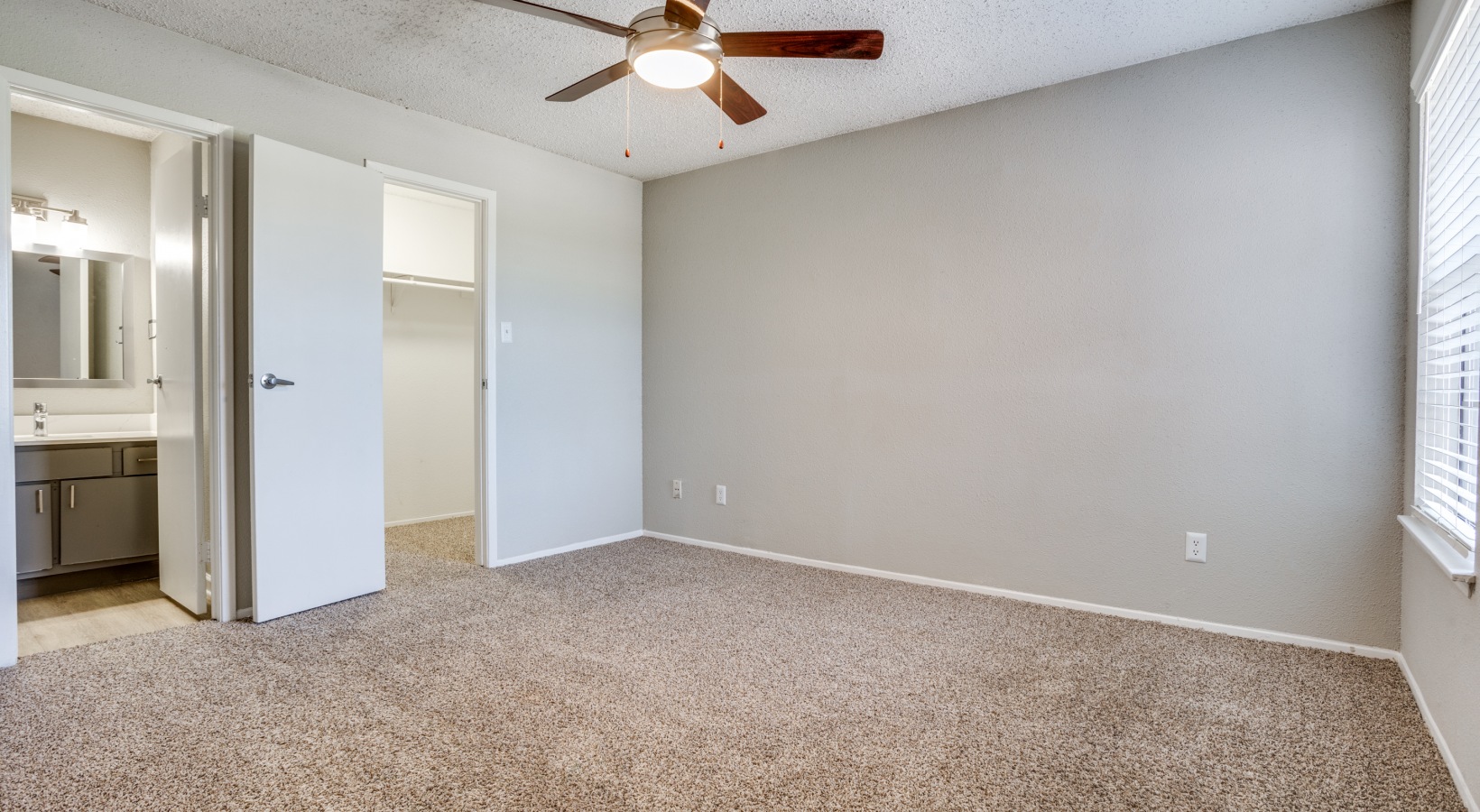 empty room with ceiling fan and carpeted floor at The Hudson