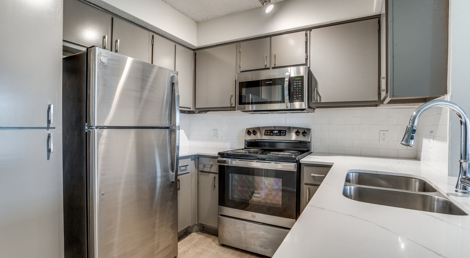 a kitchen with stainless steel appliances and a white counter at The Hudson