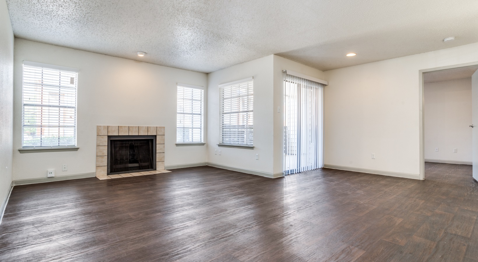 empty living room with hardwood floors and fireplace at The Hudson