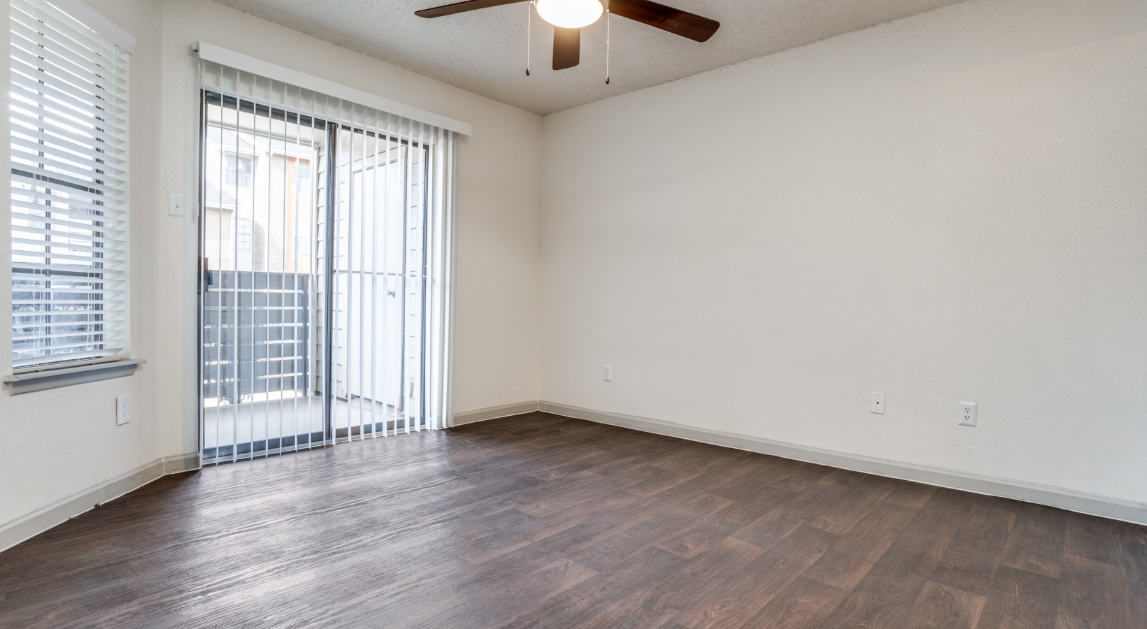 empty room with ceiling fan and hardwood floors at The Hudson