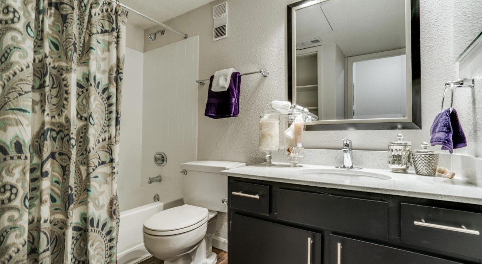 a bathroom with a shower curtain and toilet at The Hudson