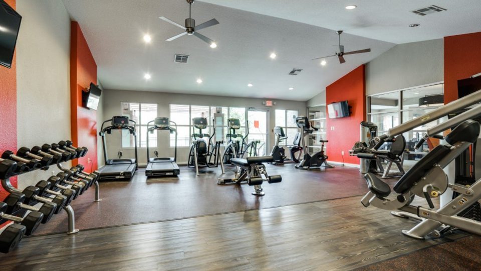 a gym room with red walls and red equipment at The Hudson
