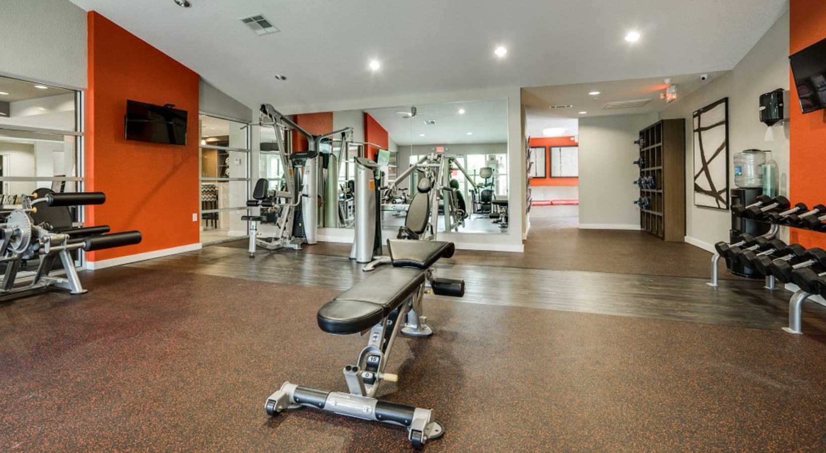 a gym room with a treadmill, weights and exercise equipment at The Hudson