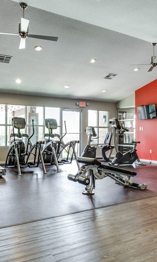 a gym room with red walls and red equipment at The Hudson