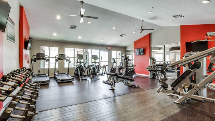 a gym room with red walls and red equipment at The Hudson