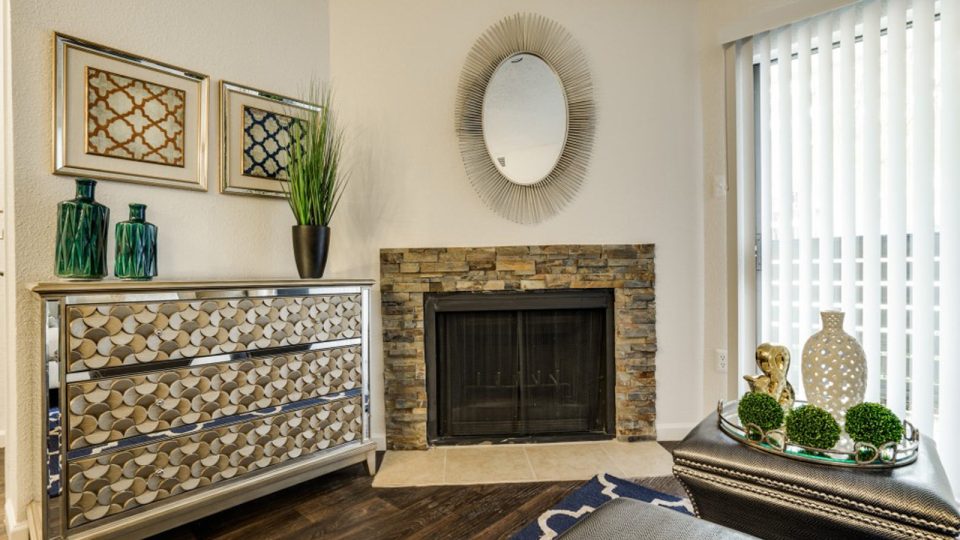 a living room with a fireplace and a mirror at The Hudson